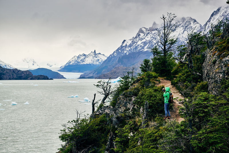 High angle view of woman standing overlooking icebergs at lago grey in patagonia, chile