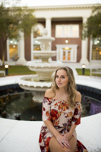 Young college girl posing by a fountain on campus