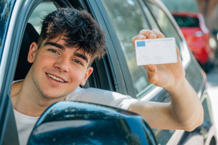 Young nobel in the car with driver's license