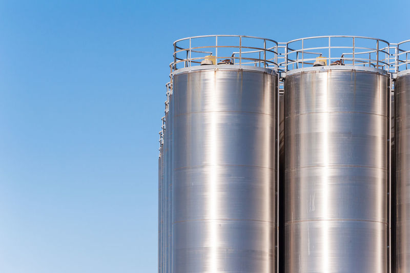 Silos in factory against sky