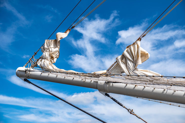 Low angle view of mast against cloudy sky