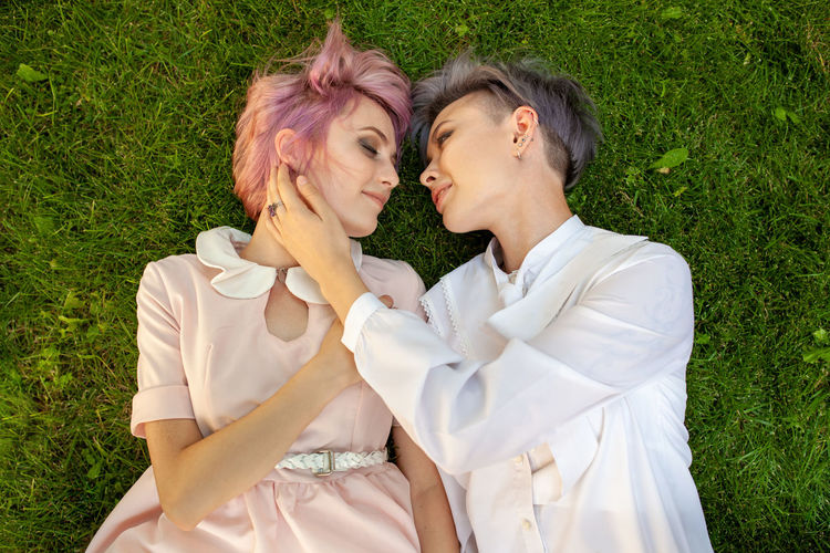 Directly above shot of romantic lesbians lying on grassy field