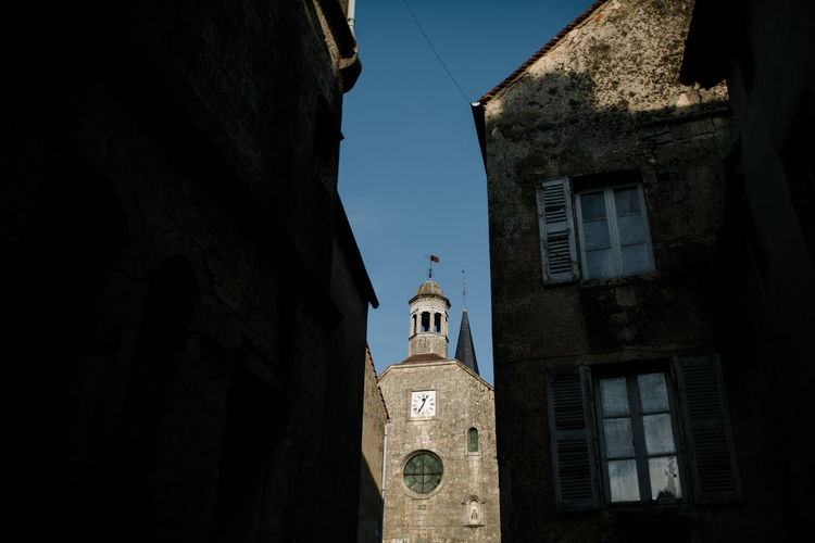 View of church spire between buildings in french countryside
