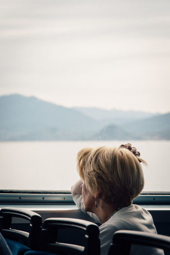 Mature woman looking through window while traveling in bus