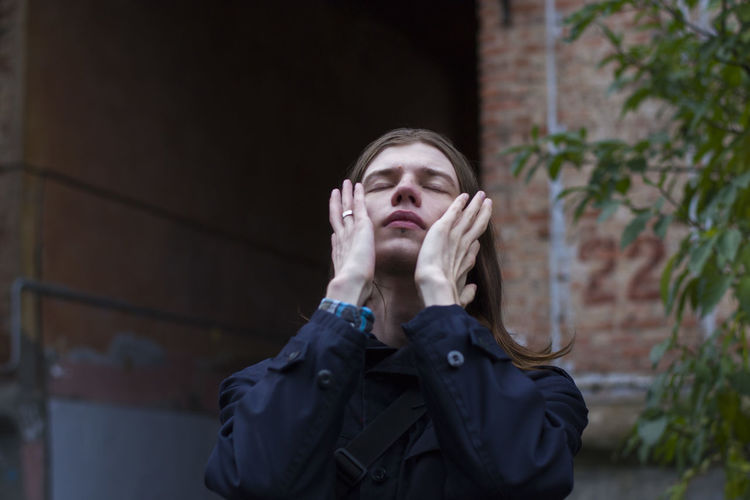 Low angle view of mid adult man with eyes closed outdoors 