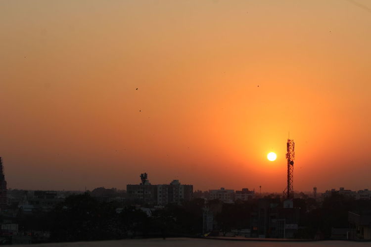 Cityscape against orange sky during sunset