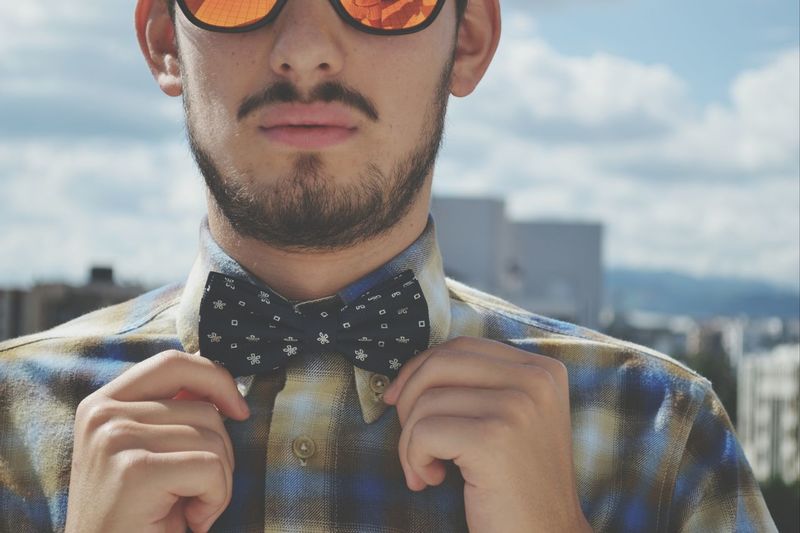 Midsection of young man adjusting bow tie