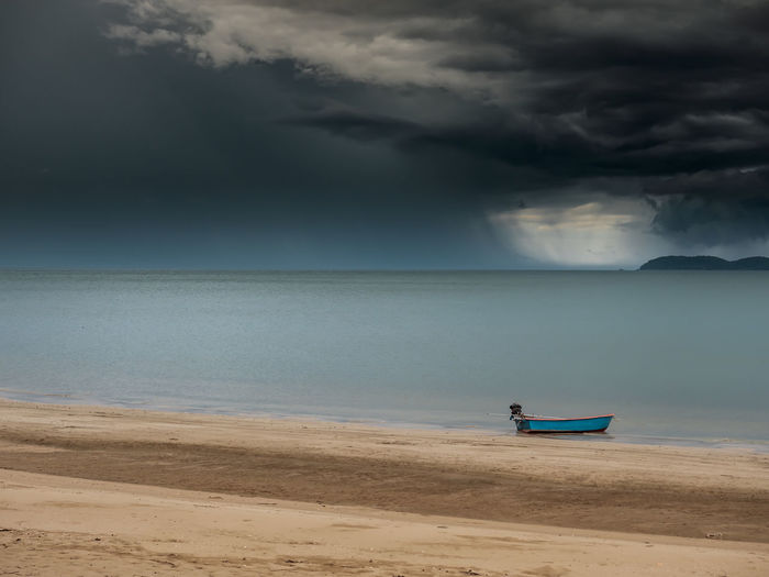 Abandon wooden ship in an empty ocean. the sky is very cloudy and a chance of thunder storm.