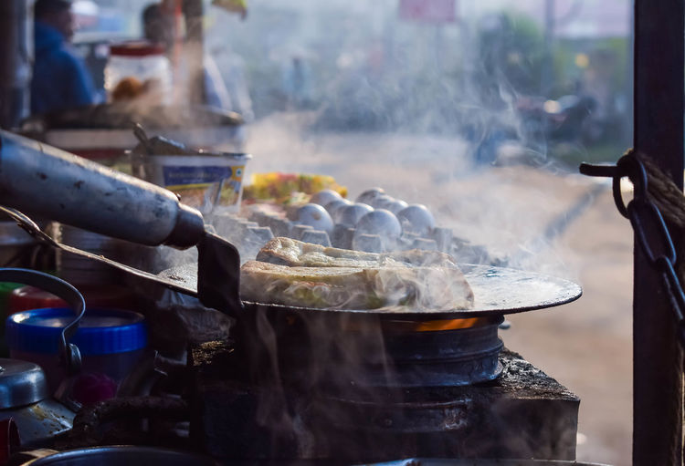 Making of egg bread roll on a hot frying pan with oil, digha beach, west bengal.