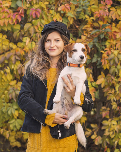 Portrait of smiling woman wearing hat standing in park during autumn