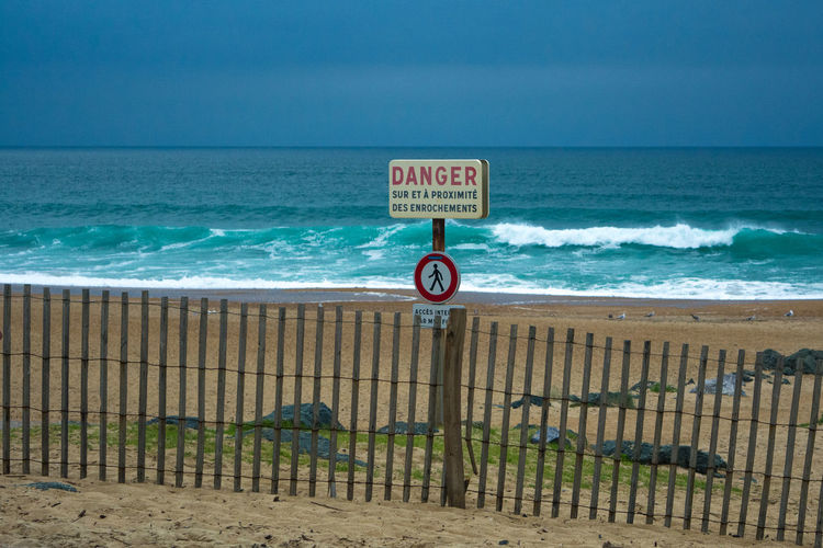 Danger sign on fence at beach