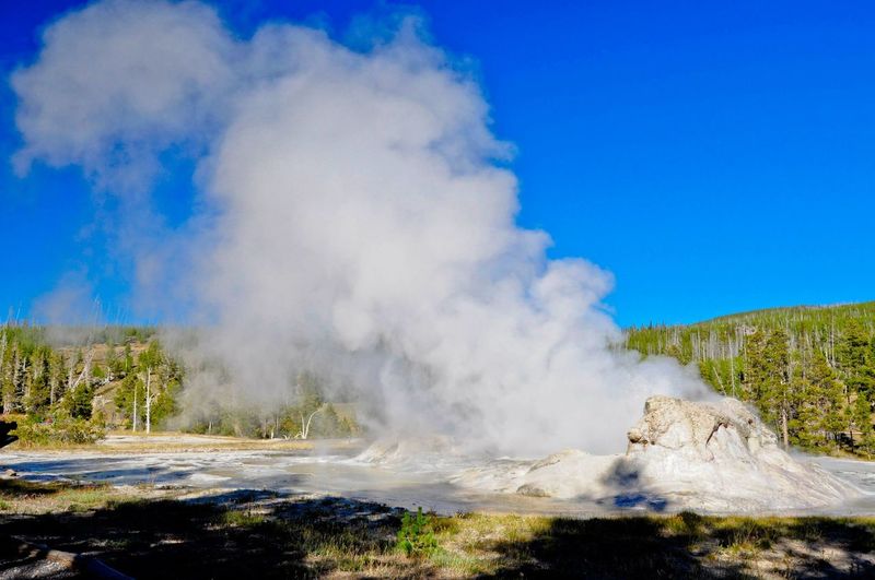 Scenic view of geyser against sky