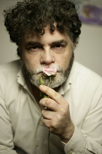 Portrait of man with flower on his lips