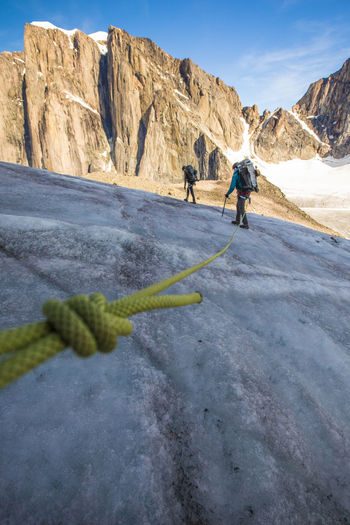 Roped mountaineering team crosses glacier high in the mountains.