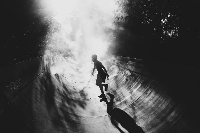Boy running on skateboard ramp at park