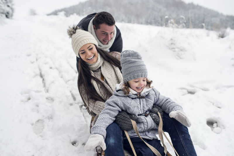Happy family on sledge in winter landscape