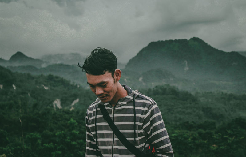 Man looking at mountains against sky