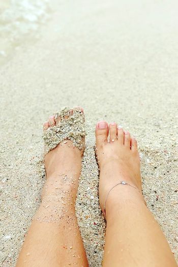 Low section of woman legs on sand