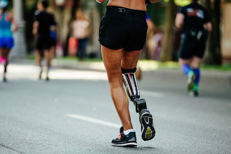 Back female runner disability in prosthesis run city streets