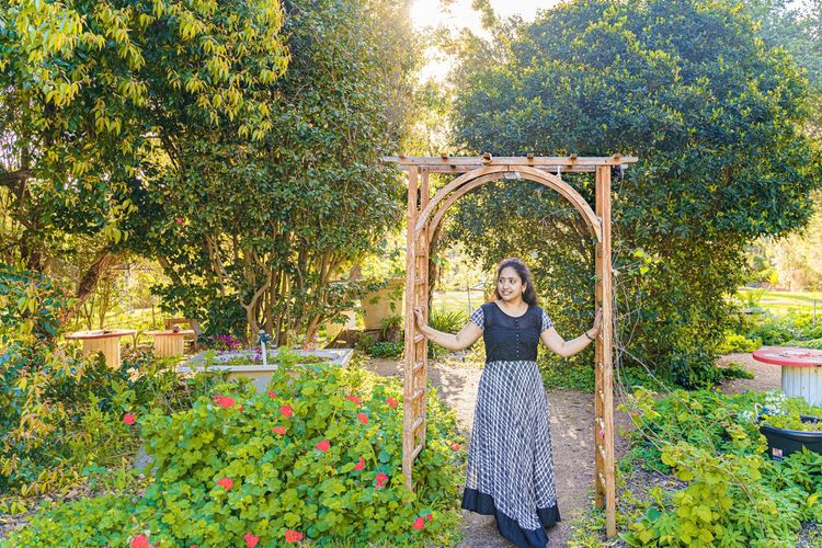 Portrait of smiling woman standing by plants