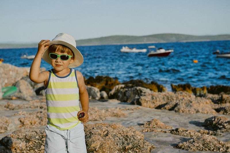 Portrait of boy wearing sunglasses while standing at beach