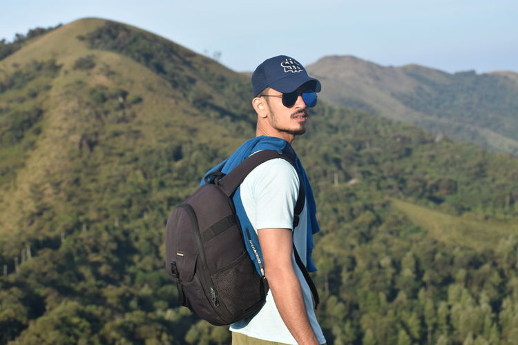 Close-up man standing on mountain against sky