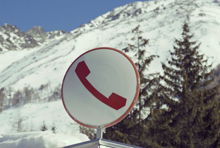Close-up of road sign on snow covered landscape