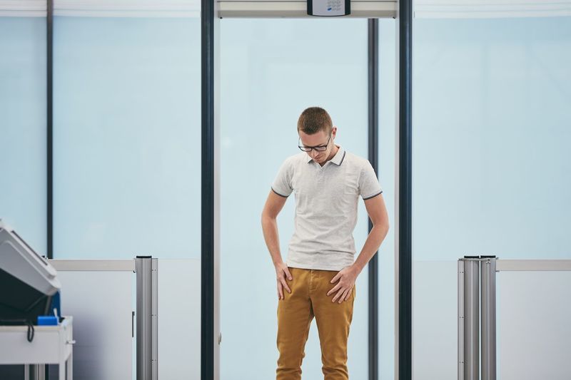 Man touching pockets while standing in airport