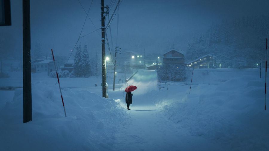 Rear view of person on snow covered road during winter