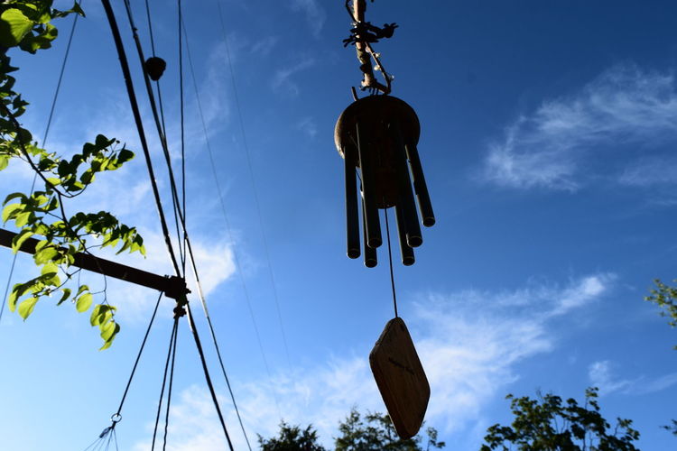Low angle view of wind chime against sky