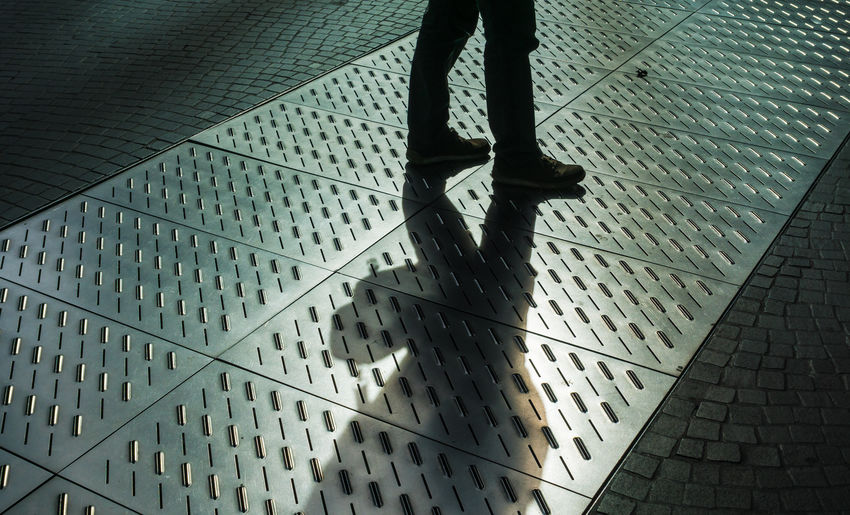 Low section of man standing on pavement
