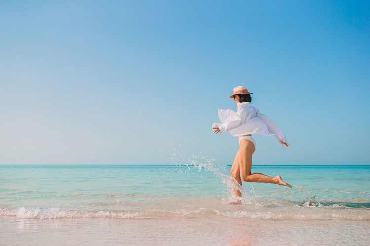 Full length of woman running at beach