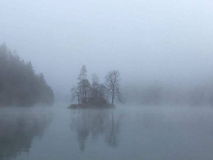 Scenic view of lake against sky in foggy weather
