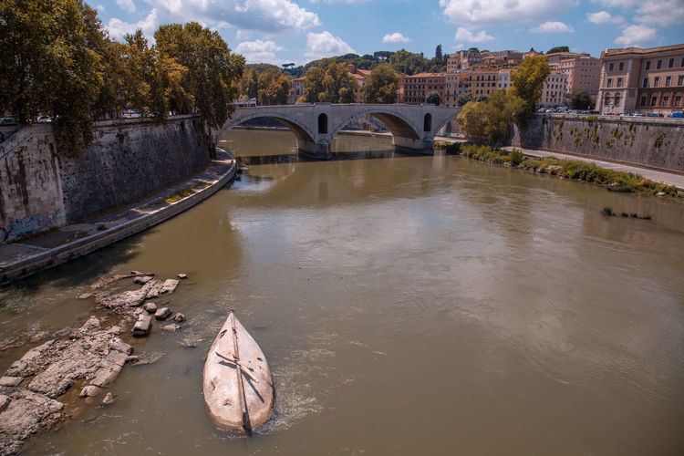 Arch bridge over river against sky