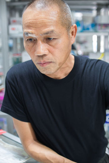 Close-up of thoughtful owner with bandage standing at shop