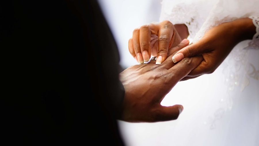 Cropped hand of couple exchanging wedding ring