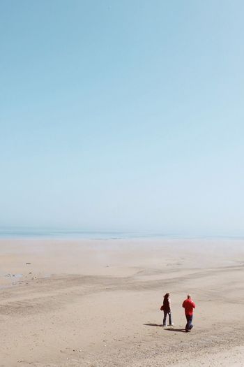 High angle view of couple walking at beach against sky