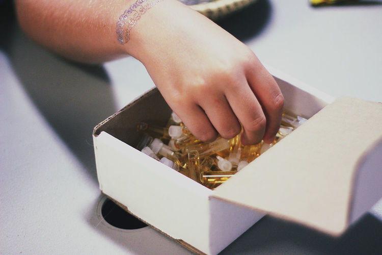 Close-up of hand holding objects in box