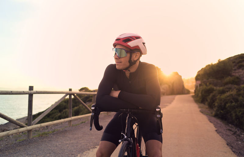 Cyclist resting at sunset during a training session.