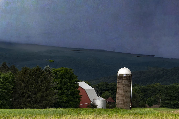 Silos in a field as storm clouds come in