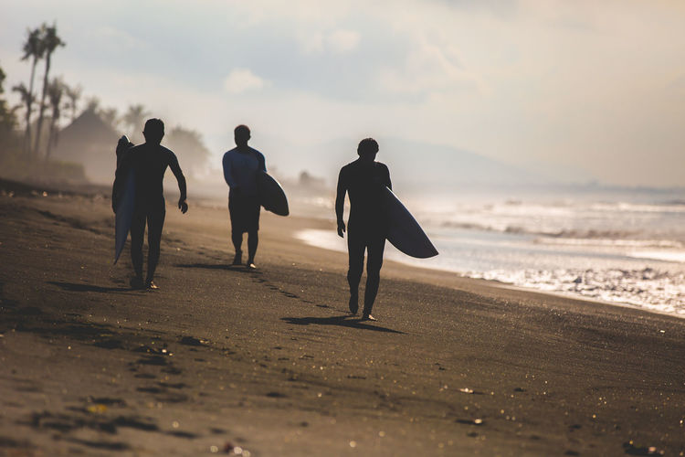 Rear view of surfers on beach
