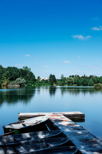 Boats moored on lake against sky