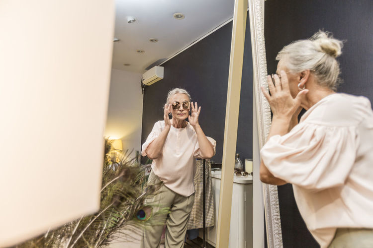 Senior woman trying on sunglasses in a boutique