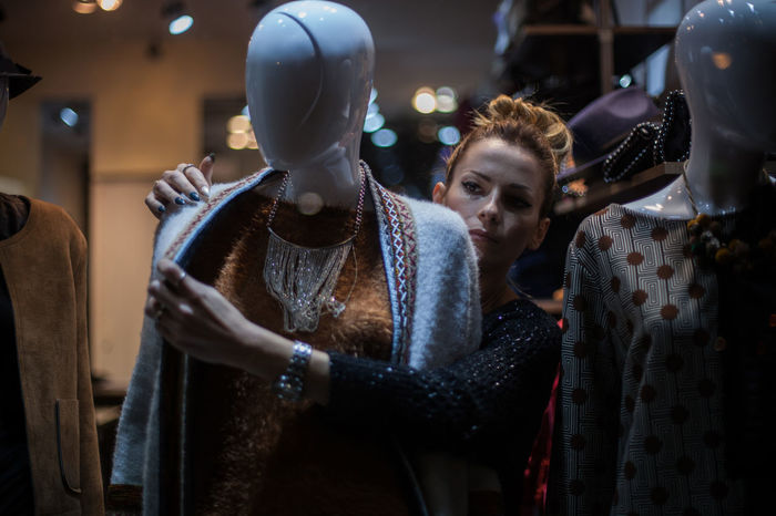 Woman wearing clothes on mannequin in store