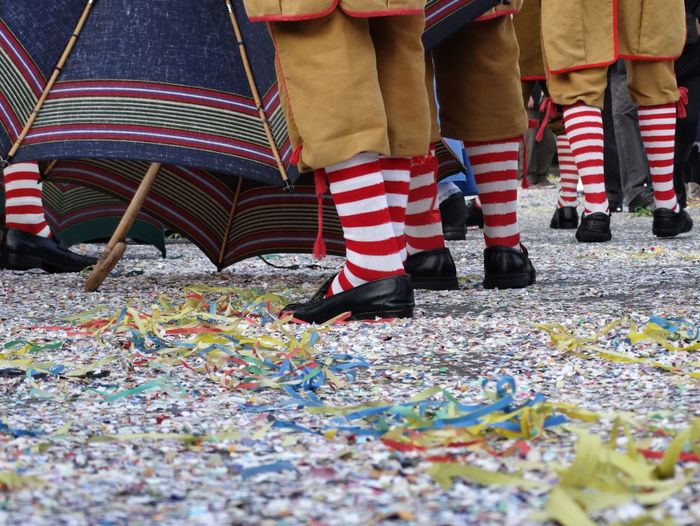 Low section of people standing by confetti on road