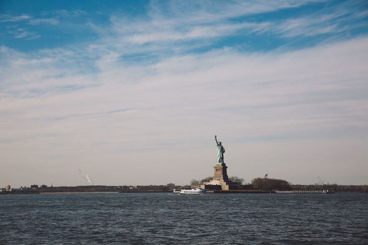 Statue of liberty by upper bay against sky