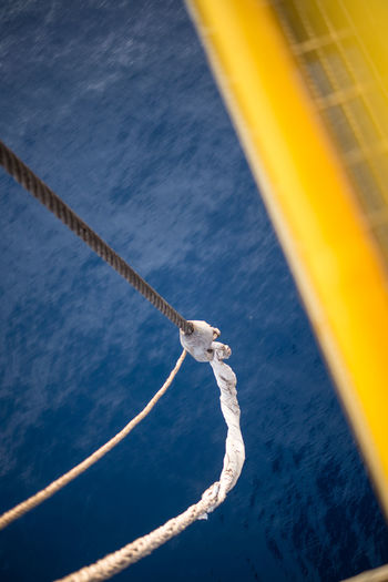 Cropped image of boat with rope on sea
