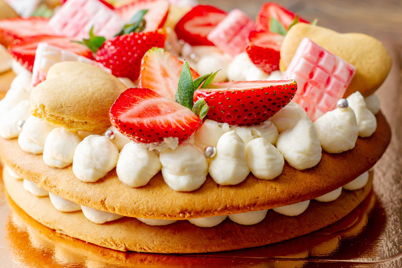Sponge cake with strawberries, pink milk chocolate bars, silver sprinkles, vanilla cream 