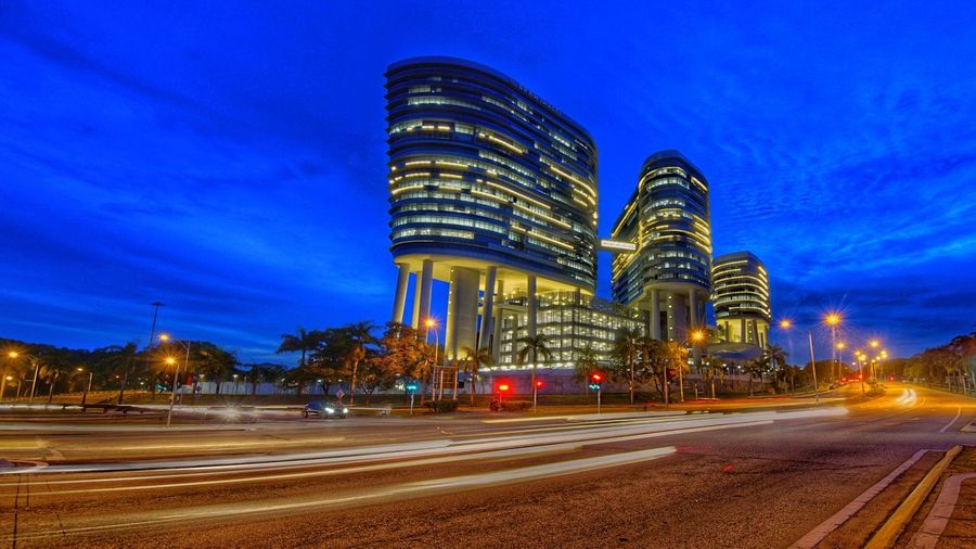 Light trails on road against blue sky