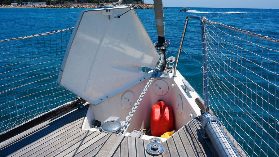 Opened anchor locker on sailing boat open sea, wooden deck